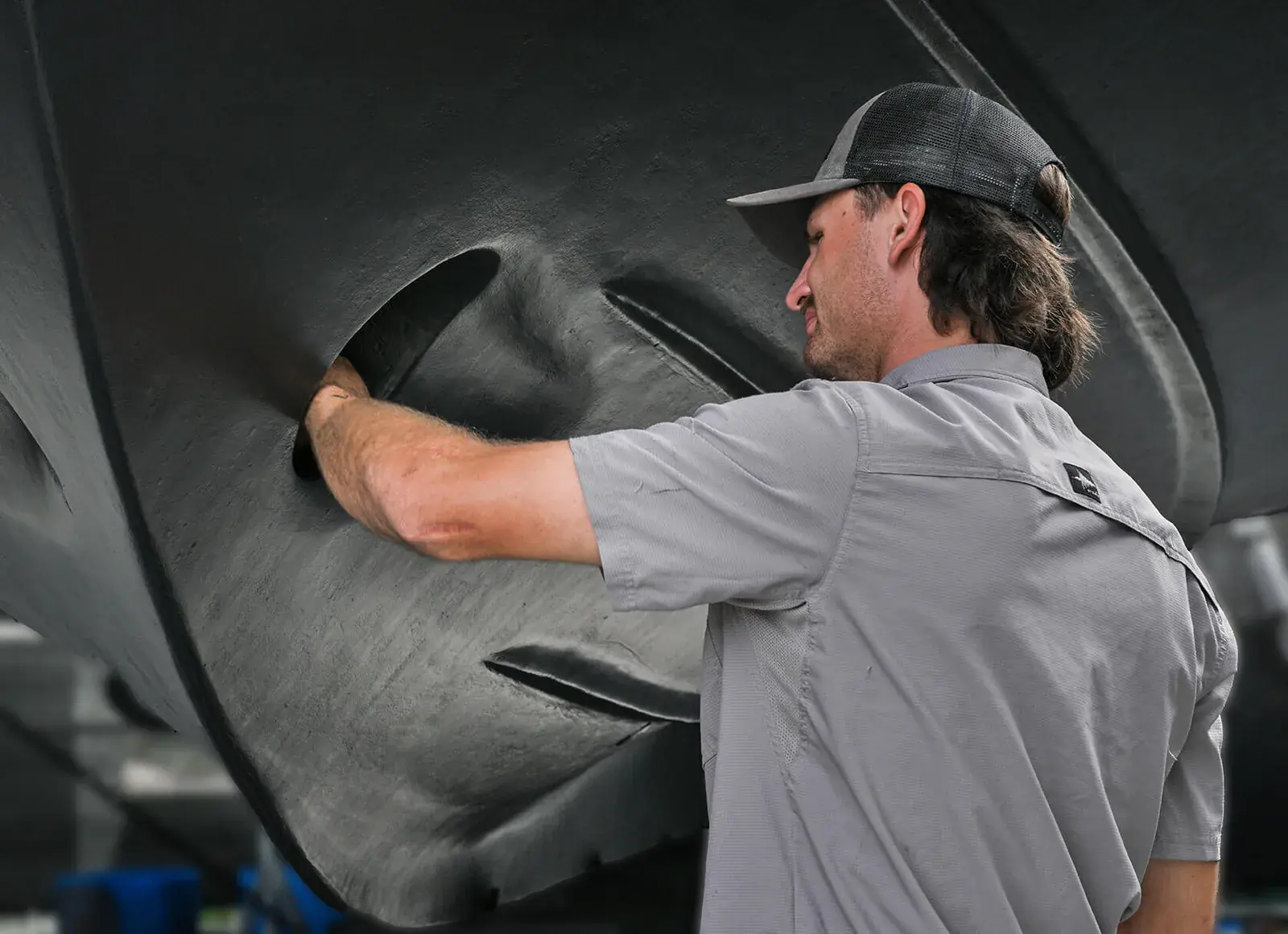 Male marina worker servicing a boat.