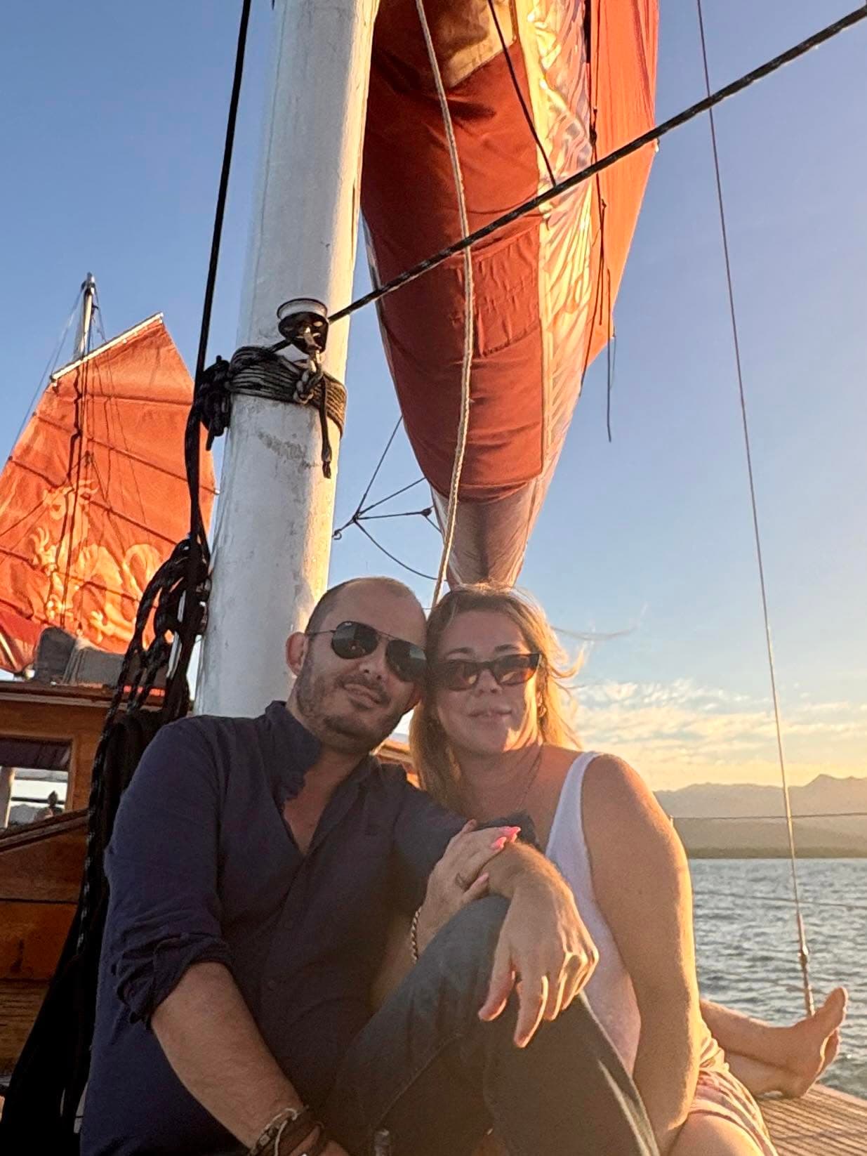 Gabriel Machuret and Kristy aboard a sailing yacht at sunset